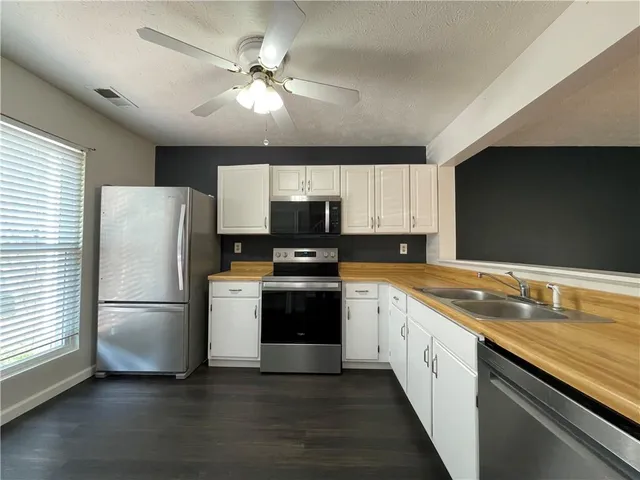 a view of a room with wooden floor and a ceiling fan