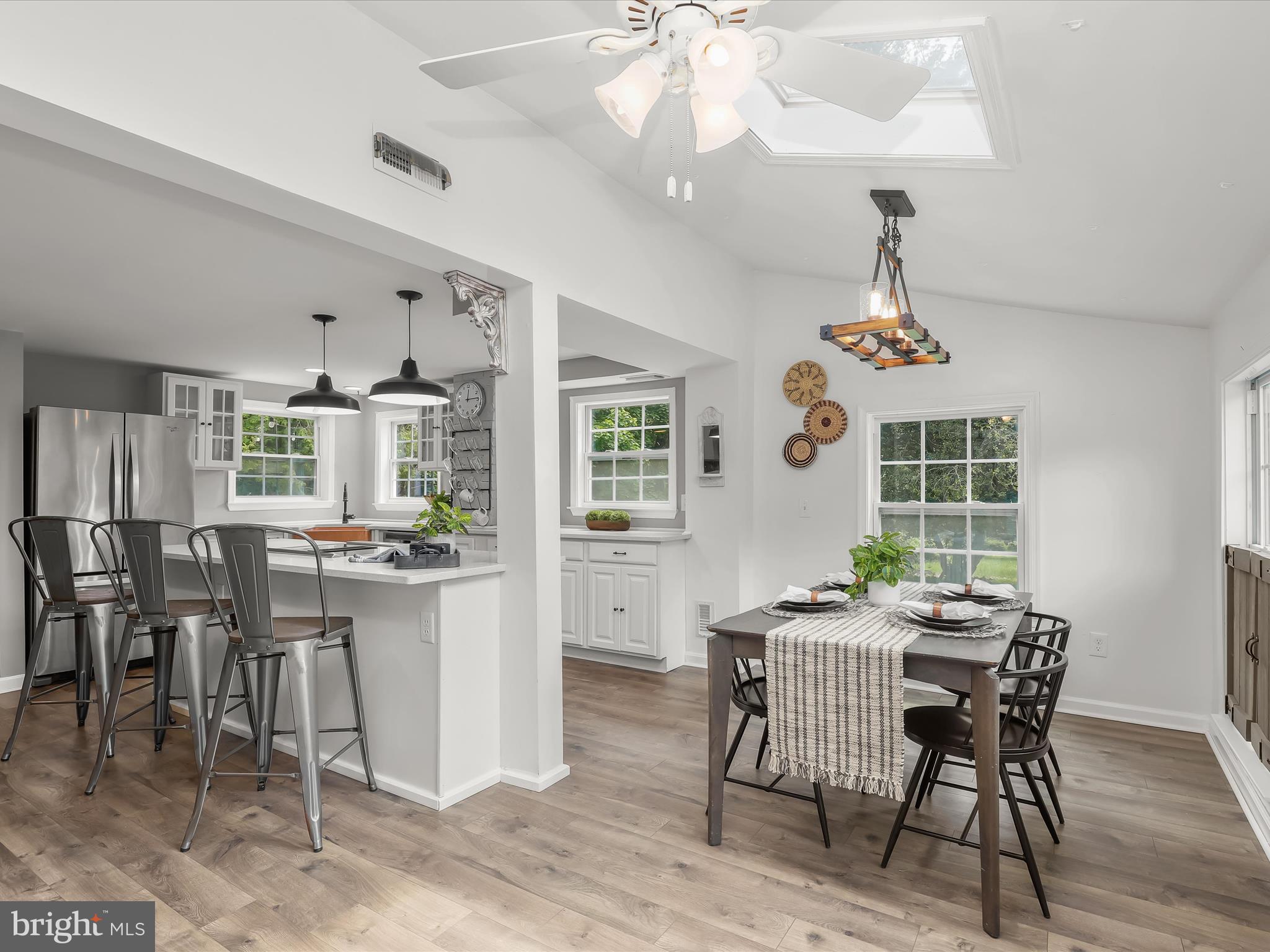 1501 Long Corner Road Mount Airy, MD 21771 - Photo 24 of 116 a dining room with wooden floor a chandelier a wooden table and chairs