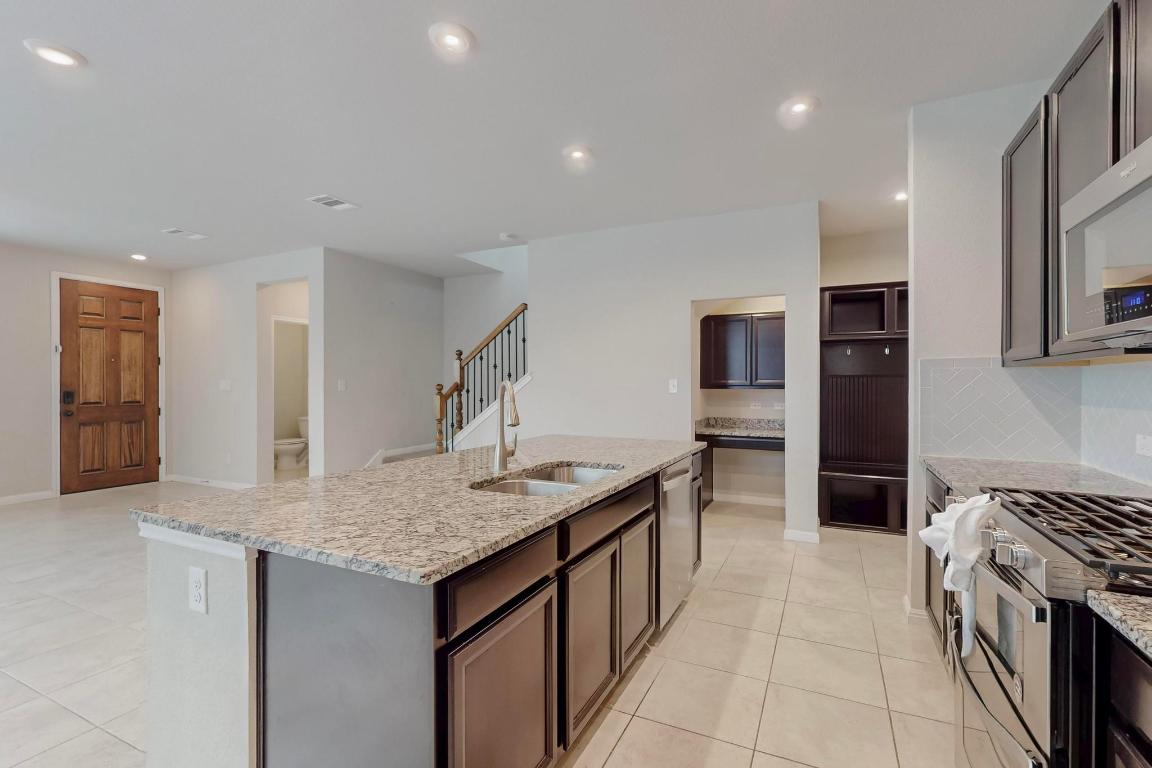 2908 Harvester Lane Round Rock, TX 78664 - Photo 11 of 40 a kitchen with stainless steel appliances granite countertop a sink and a refrigerator