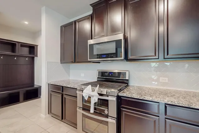 a kitchen with granite countertop stainless steel appliances and wooden cabinets