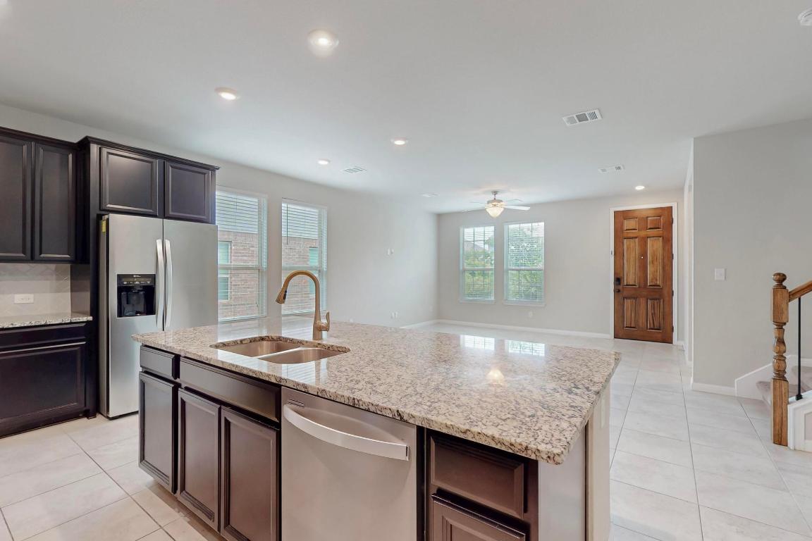 2908 Harvester Lane Round Rock, TX 78664 - Photo 13 of 40 a kitchen with stainless steel appliances granite countertop a sink and a refrigerator