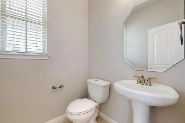a bathroom with a toilet a sink and a window