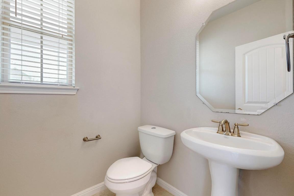 2908 Harvester Lane Round Rock, TX 78664 - Photo 14 of 40 a bathroom with a toilet a sink and a window