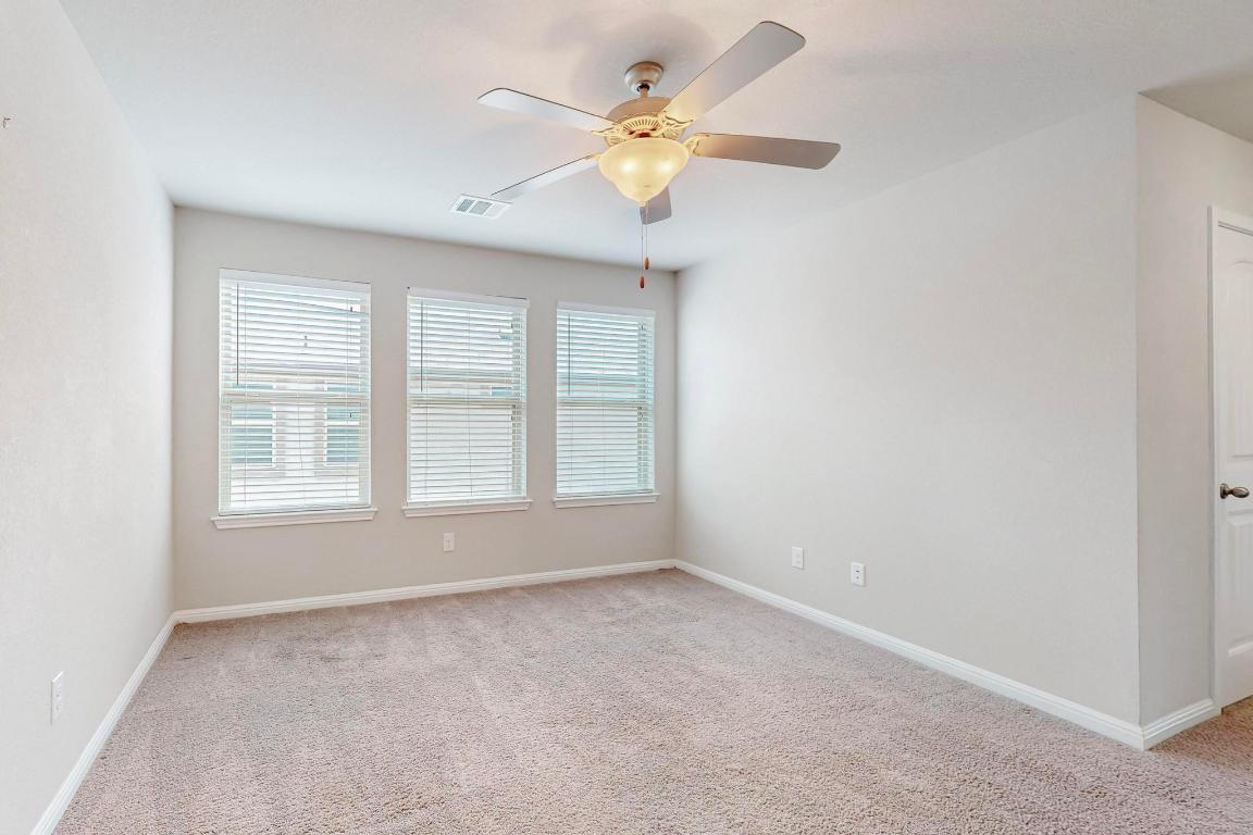 2908 Harvester Lane Round Rock, TX 78664 - Photo 15 of 40 an empty room with chandelier fan and windows
