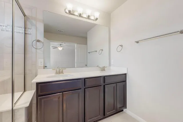 a bathroom with a double vanity sink and mirror