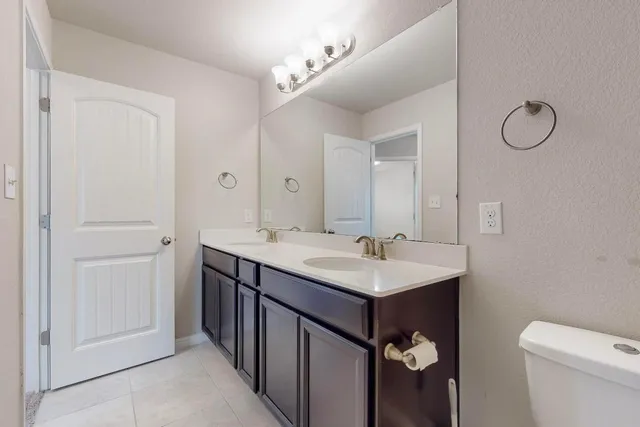 a bathroom with a sink toilet and a mirror