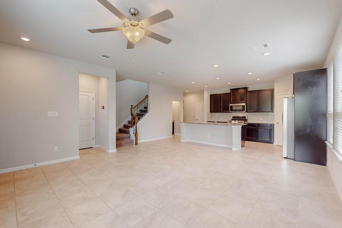 2908 Harvester Lane Round Rock, TX 78664 - Photo 8 of 40 a view of a kitchen with a sink and a ceiling fan