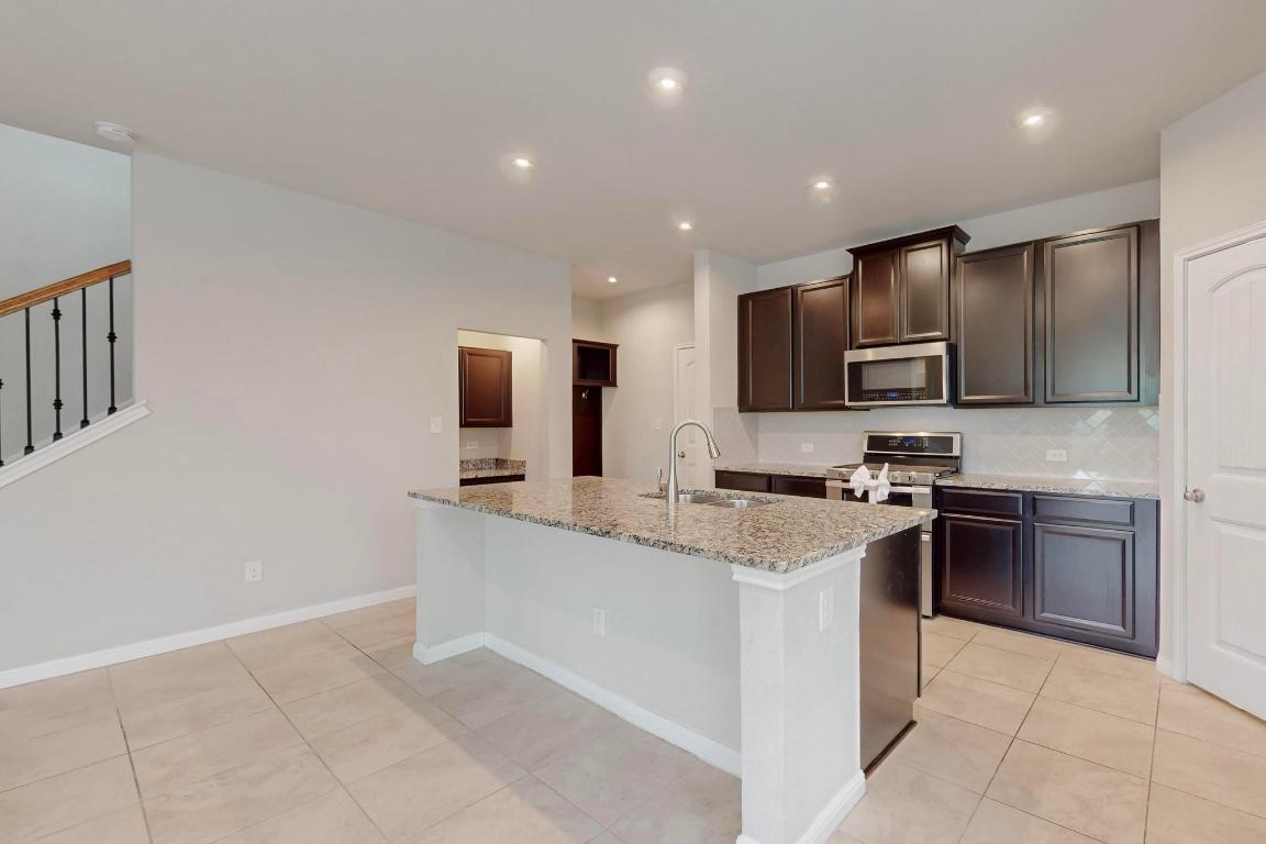 2908 Harvester Lane Round Rock, TX 78664 - Photo 10 of 40 a kitchen with stainless steel appliances granite countertop a stove top oven a sink and dishwasher