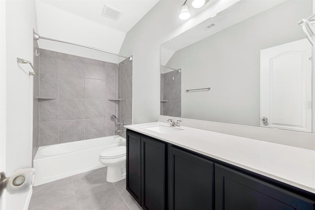 7640 Rhyner Way Fort Worth, TX 76137 - Photo 34 of 40 Spa-inspired primary bathroom featuring a double vanity with white quartz countertop, matte black cabinetry, and integrated sink fixtures