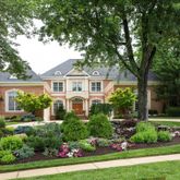 a front view of a house with a yard and potted plants