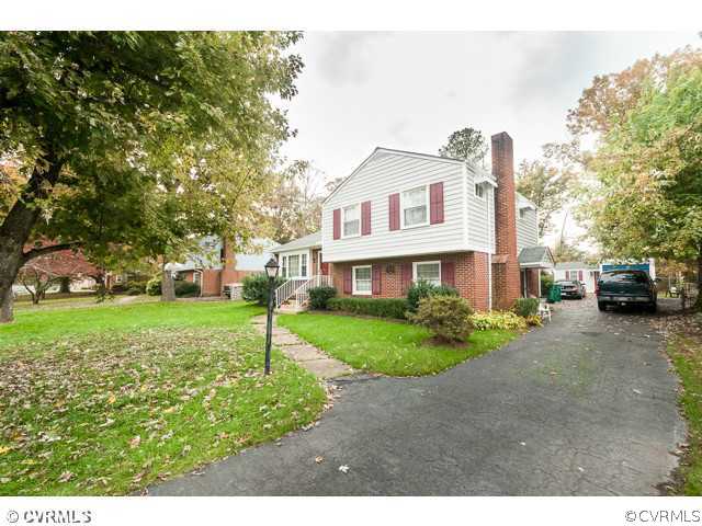 6433 Commander Road Richmond, VA 23224 - Photo 11 of 21 a front view of a house with a yard and a large tree
