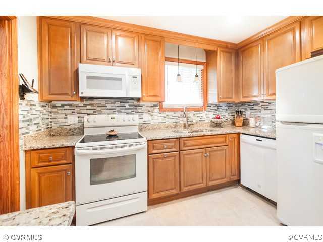 6433 Commander Road Richmond, VA 23224 - Photo 17 of 21 a kitchen with a stove a sink and a refrigerator