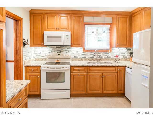 6433 Commander Road Richmond, VA 23224 - Photo 19 of 21 a kitchen with stainless steel appliances granite countertop a stove a sink and a microwave