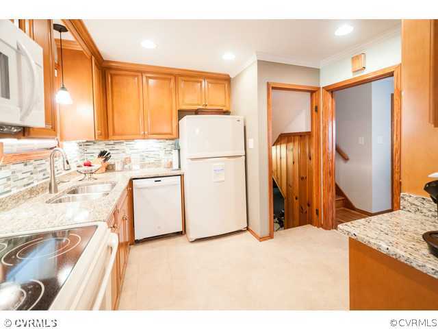 6433 Commander Road Richmond, VA 23224 - Photo 2 of 21 a kitchen with granite countertop a refrigerator a sink and a stove