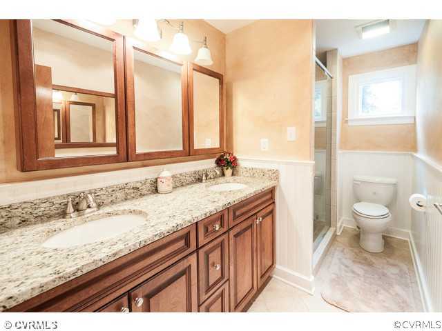 6433 Commander Road Richmond, VA 23224 - Photo 6 of 21 a bathroom with a granite countertop sink a toilet and a large mirror