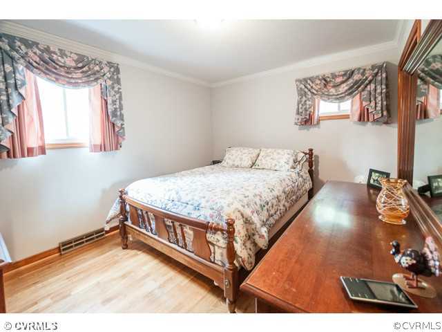 6433 Commander Road Richmond, VA 23224 - Photo 7 of 21 a bedroom with a bed window and a table