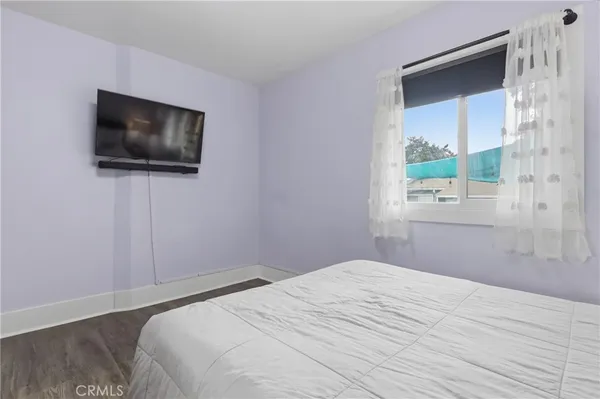a bedroom with a bed and a a flat screen tv