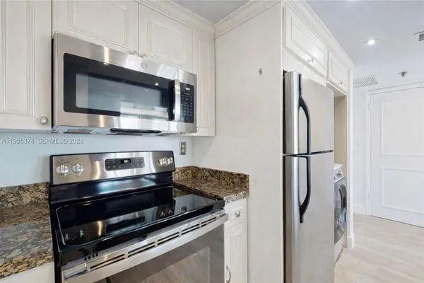 a kitchen with stainless steel appliances a refrigerator stove and microwave