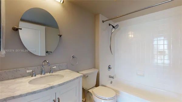 a bathroom with a granite countertop toilet sink and shower
