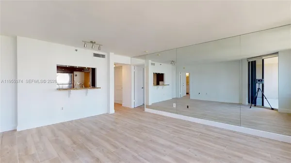 a view of a big room with wooden floor and windows