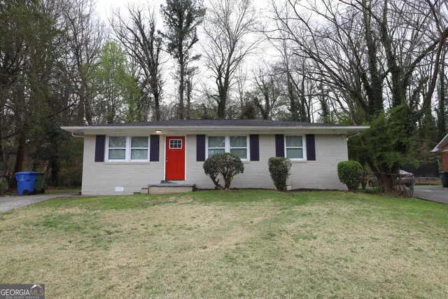 a view of a house with a yard and large tree