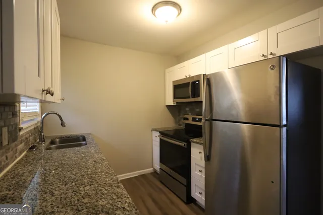a kitchen with a refrigerator sink and stove