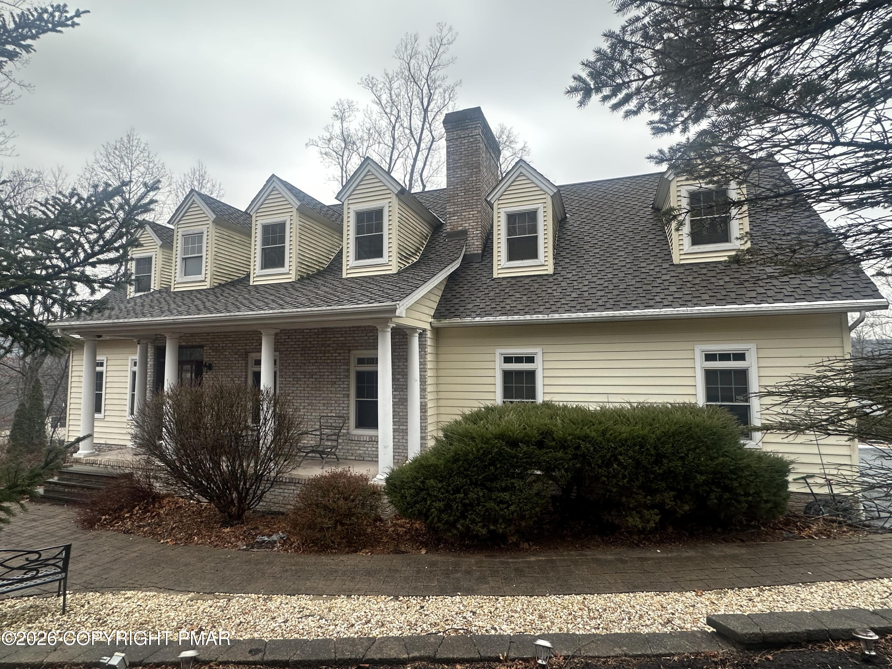 a view of a white house next to a yard