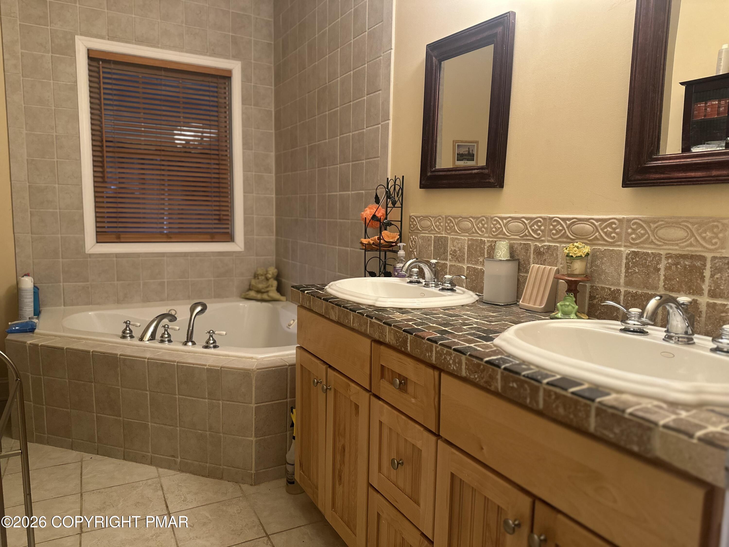 2 Shepard Court Delaware Water Gap, PA 18327 - Photo 30 of 57 a bathroom with a double vanity sink large mirror and bathtub