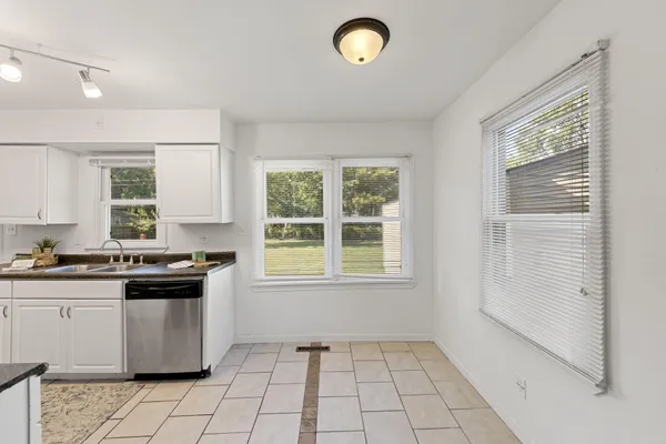 a kitchen with granite countertop a stove a sink dishwasher and a refrigerator
