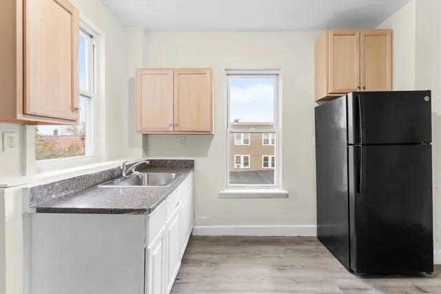 a kitchen with granite countertop a refrigerator and a sink