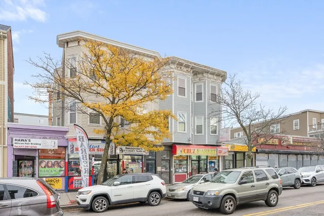 a front view of a building with cars parked