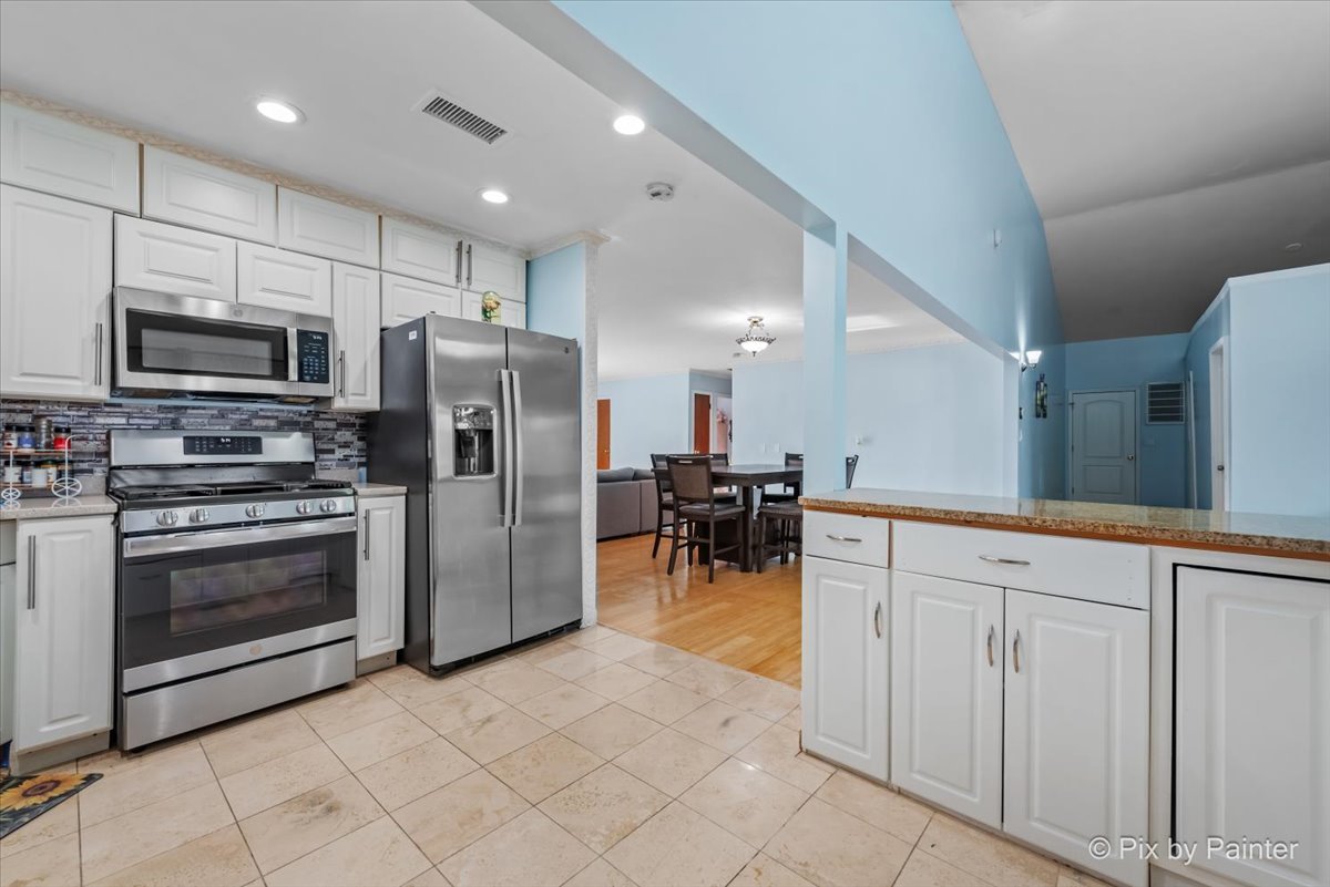 27 South Oltendorf Road Streamwood, IL 60107 - Photo 18 of 31 a kitchen with stainless steel appliances granite countertop a refrigerator a stove a sink and a microwave