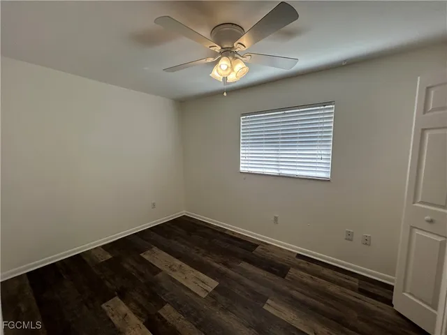 a view of wooden floor and a chandelier fan in a room