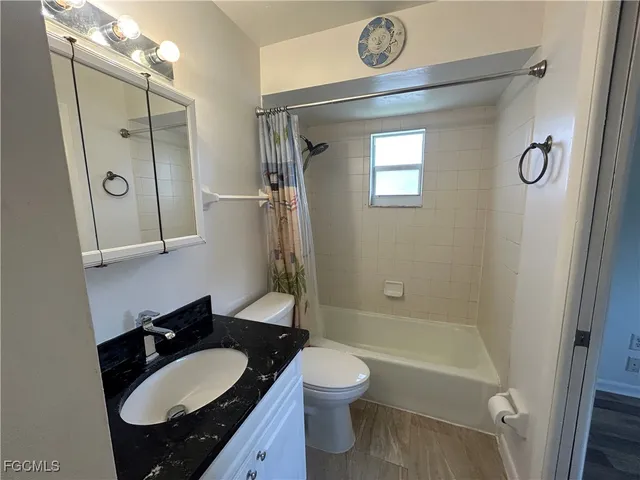 a bathroom with a granite countertop sink toilet a mirror and shower