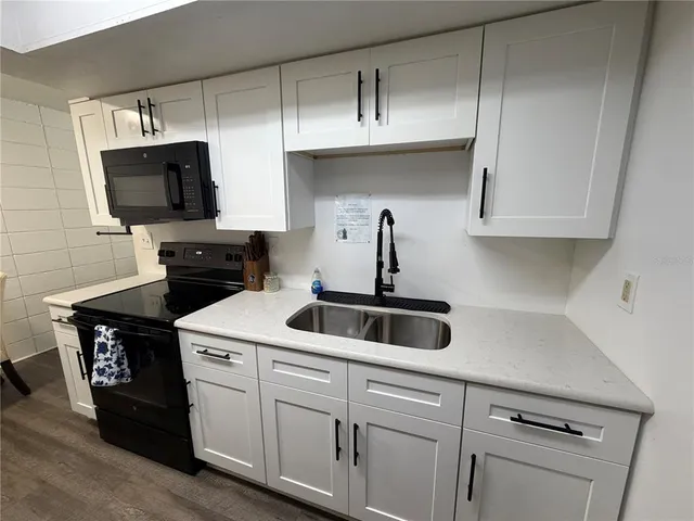a kitchen with a sink and a stove top oven