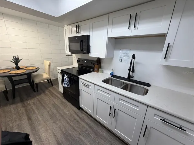 a kitchen with a sink appliances and cabinets