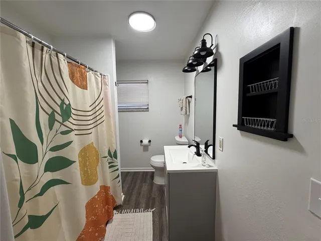a bathroom with a sink a mirror and a shower curtain