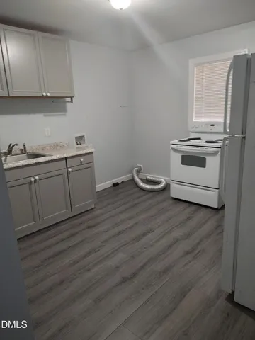 a kitchen with granite countertop a stove and white cabinets