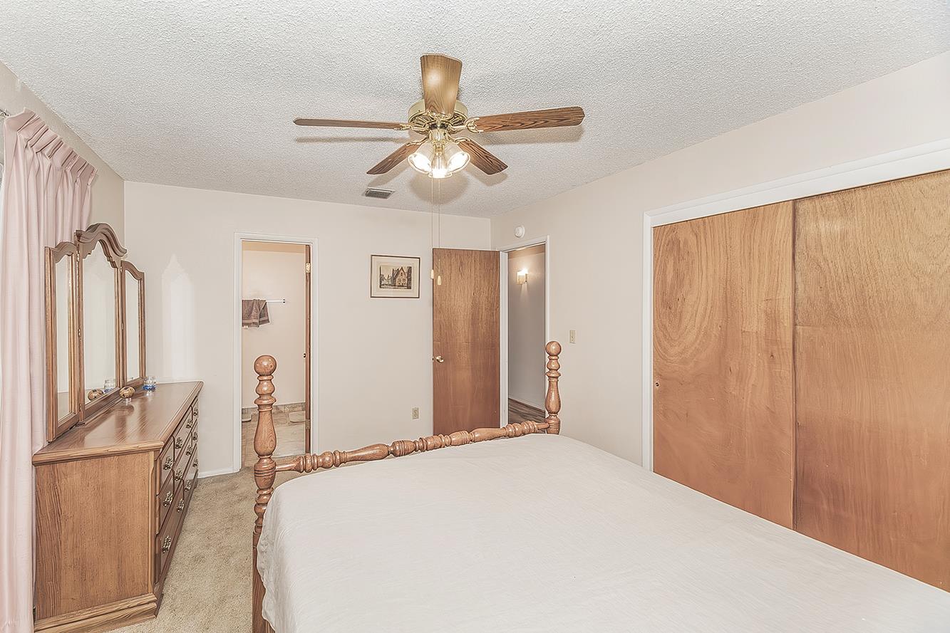 1350 Mill Street Selma, CA 93662 - Photo 19 of 47 a bedroom with a large bed and a chandelier