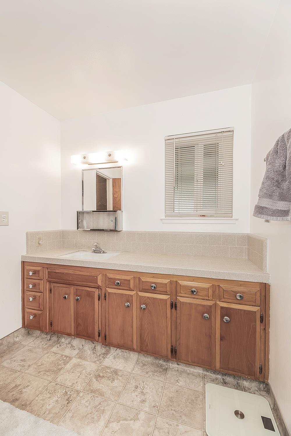 1350 Mill Street Selma, CA 93662 - Photo 20 of 47 a spacious bathroom with a granite countertop sink and a mirror