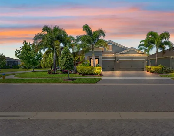 a front view of a house with a yard and trees