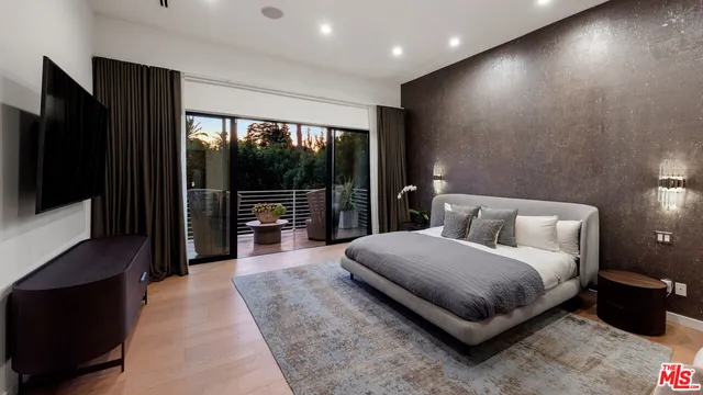 a spacious bedroom with a bed and a large window