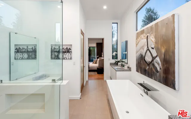 a en suite spacious bathroom with a tub double vanity and shower