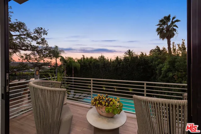a view of a balcony with chairs and a potted plant