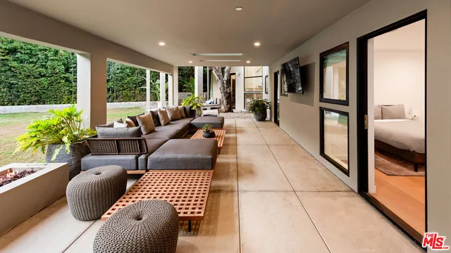 a living room with furniture and a floor to ceiling window