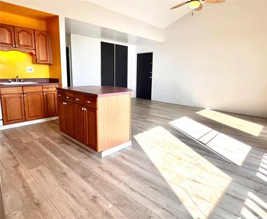 a room with kitchen island granite countertop wooden floor a top and a counter top space
