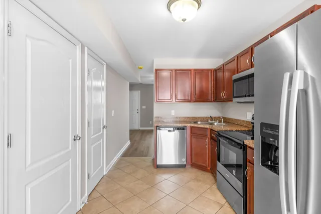 a kitchen with stainless steel appliances granite countertop a refrigerator and a stove top oven