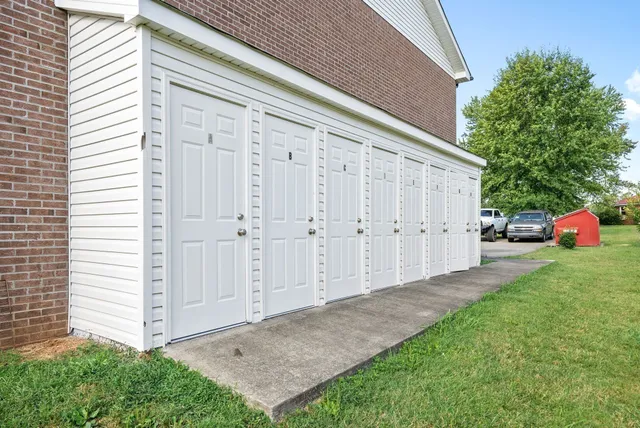 a view of backyard with small cabin and potted plants