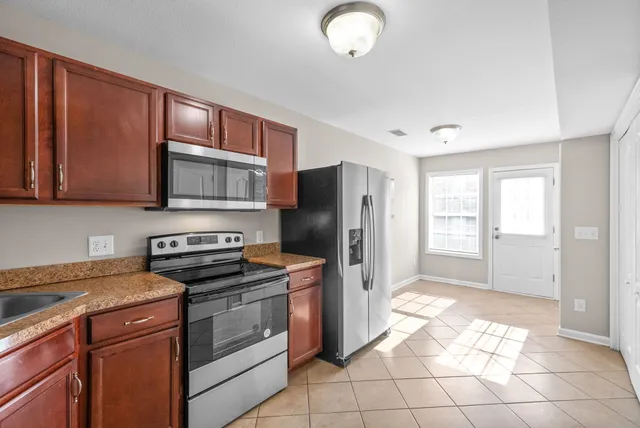 a kitchen with stainless steel appliances granite countertop a stove a refrigerator and a sink with granite countertops