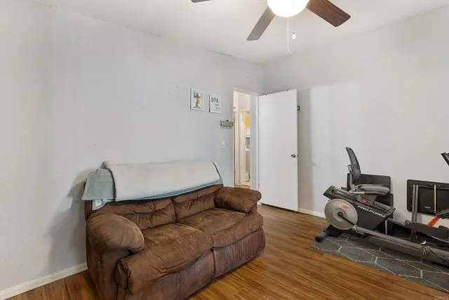a living room with furniture and a ceiling fan